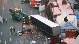 Petugas menderek truk yang menabrak Pasar Natal di Berlin, Jerman, Selasa (20/12). Akibat kejadian ini, dikabarkan 12 orang tewas dan 48 orang terluka. (REUTERS / Fabrizio Bensch)