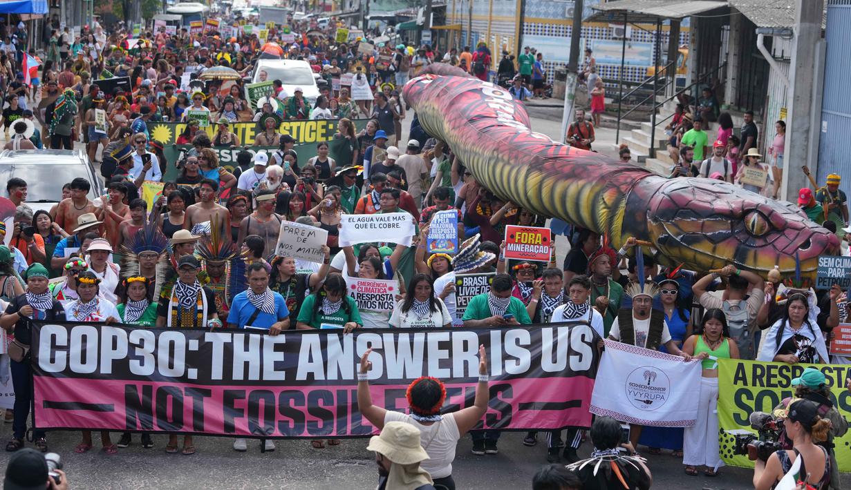 Para pengunjuk rasa menuntut penghentian proyek-proyek eksploitasi minyak, mineral, dan pembangunan infrastruktur seperti jalur kereta api di wilayah mereka. Tampak dalam foto, para aktivis berdemonstrasi dalam aksi protes iklim di tengah-tengah perhelatan Konferensi Tingkat Tinggi Perubahan Iklim PBB (COP30), di Belem, Brasil, Senin 17 November 2025. (AP Photo/Andre Penner)