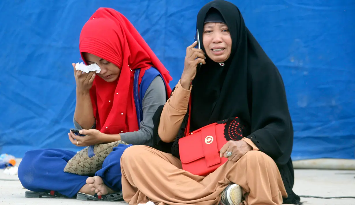 Kerabat menangis di pelabuhan Tigaras mengetahui keluarganya menjadi korban KM Sinar Bangun yang tenggelam di Danau Toba, Sumatera Utara, Rabu (20/6). KM Sinar Bangun yang mengangkut 128 penumpang tenggelam pada Senin (18/6) sore. (AP/Binsar Bakkara)