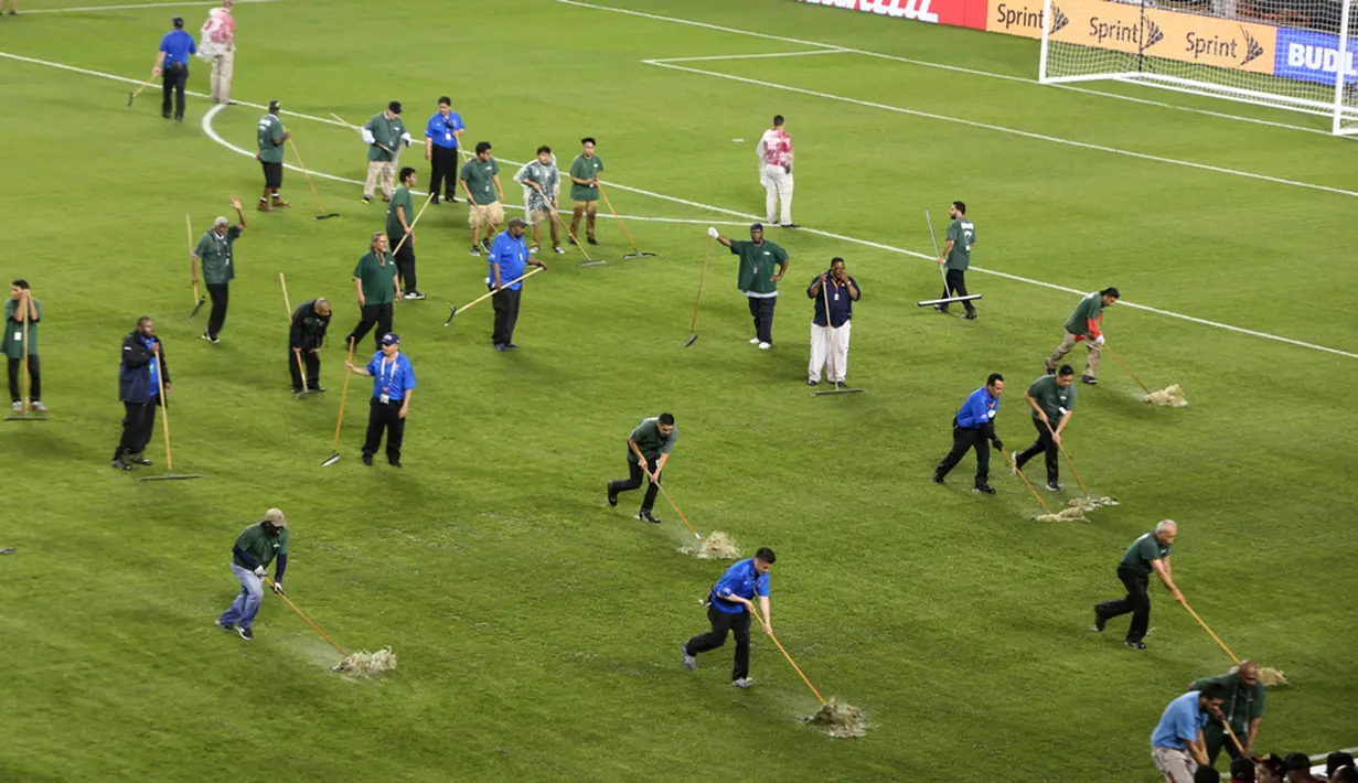 Petugas membersihkan genangan air akibat hujan badai yang menunda laga Cile melawan Kolombia dalam semifinal Copa America Centenario 2016 di Stadion Soldier Field, Chicago, AS, Kamis (23/6/2016) pagi WIB. (AFP/Tasos Katopodis)