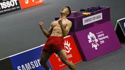 Selebrasi pebulu tangkis Indonesia Jonatan Christie (kanan) usai menundukkan pebulu tangkis Jepang Kenta Nishimoto di semifinal Asian Games 2018, Jakarta, Senin (27/8). Selebrasi Jonatan membuat heboh penonton dan warganet. (AP Photo/Achmad Ibrahim)