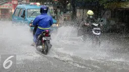 Sejumlah pengedara motor nekat menerobos banjir di Depok, Jumat (12/2). Badan Meteorologi, Klimatologi, dan Geofisika (BMKG) menyatakan bahwa Indonesia akan memasuki puncak musim hujan pada Januari-Februari 201. (Liputan6.com/Yoppy Renato)