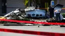 Tim investigasi menyelidiki reruntuhan pesawat kecil yang jatuh ke area parkir pusat perbelanjaan di Santa Ana, California, Senin (6/8). Pilot dari pesawat bermesin ganda Cessna itu mendeklarasikan keadaan darurat sesaat sebelum jatuh. (AP/Jae C. Hong)