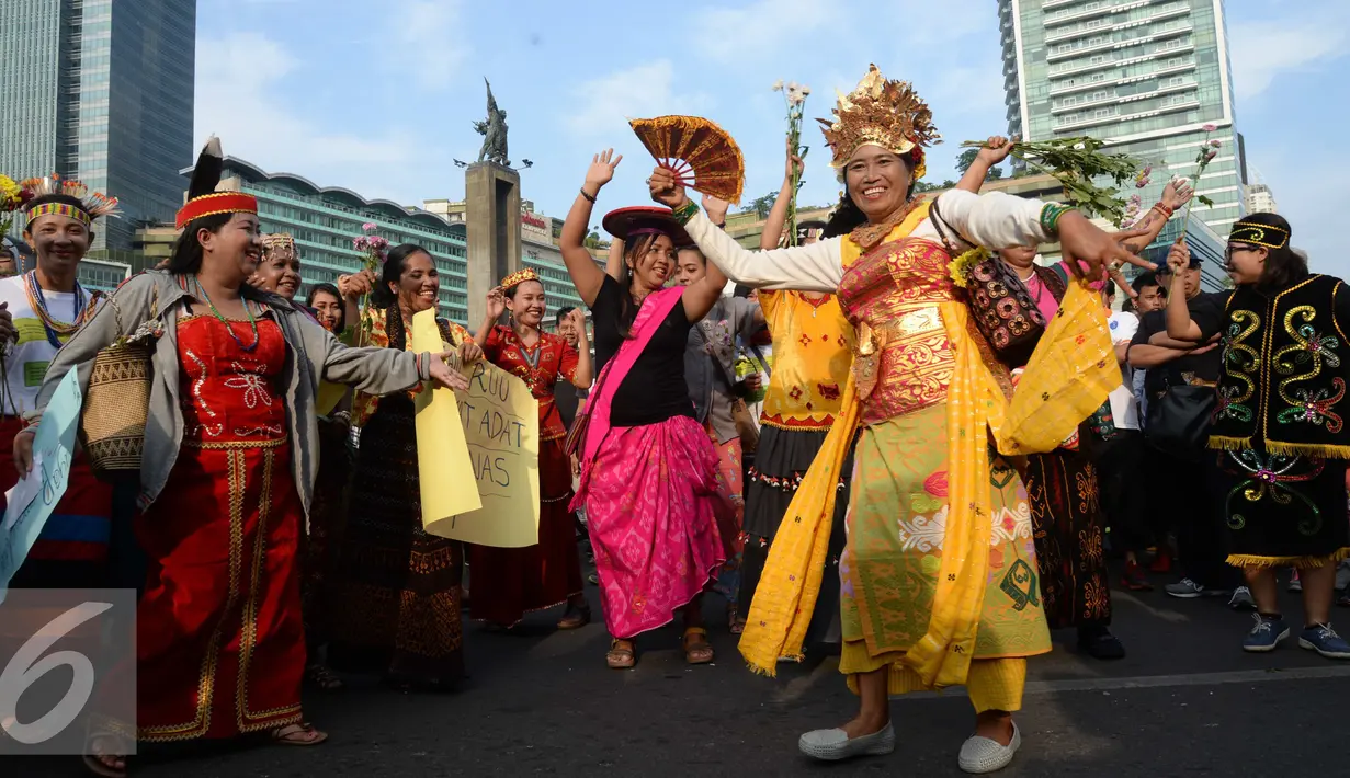 Peserta pawai budaya memperingati Hari Internasional Masyarakat Adat se-Dunia menari di Bundaran HI, Jakarta, Minggu (7/8). (Liputan6.com/Angga Yuniar)