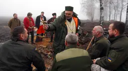 Seorang pendeta memberkati tentara Garda Nasional Ukraina saat memperingati Natal dekat perbatasan Rusia di Kharkiv, Ukraina, 24 Desember 2022. Pasukan pertahanan Ukraina telah memukul mundur serangan Rusia dekat 19 permukiman di wilayah seperti Sumy, Kharkiv, Donetsk, dan Luhansk selama beberapa hari terakhir. (AP Photo/Andrii Marienko)