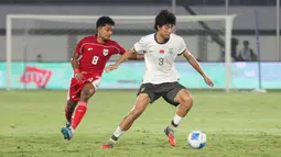 Bertanding di Indomilk Arena, Tangerang, Banten, Rabu (11/2/2026) malam, Timnas Indonesia U-17 kalah 2-3. Tampak dalam foto, pemain Timnas Indonesia U-17, Chico Jericho Yarangga (kiri) berebut bola dengan Zhao Songyuan (China) dalam laga uji coba di Indomilk Arena, Tangerang, Banten, Rabu (11/2/2026) malam. (Bola.com/Abdul Aziz)