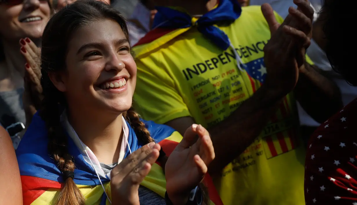 Seorang wanita bereaksi ketika Parlemen Catalonia mendeklarasikan kemerdekaan dari Spanyol di luar gedung parlemen di Barcelona, Jumat (27/10). Sejumlah pendukung kemerdekaan, turun ke jalan dan menyanyikan lagu tradisional Catalan. (AP/Santi Palacios)