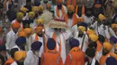 Kepala pendeta Sikh Jagtar Singh (tengah) membawa teks pokok agama Sikhisme, Guru Granth Sahib selama prosesi keagamaan dari Gurudwara Ramsar ke Akal Takht Sahib di Kuil Emas, Amritsar, India, Rabu (19/8/2020). Acara ini untuk memperingati 416 tahun pelantikan Guru Granth Sahib. (NARINDER NANU/AFP)