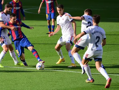 Bek Osasuna, Raul Navas (kiri) berebut bola dengan penyerang Barcelona, Lionel Messi pada pekan ke-11 Liga Spanyol 2020-2021di stadion Camp Nou, Minggu (29/11/2020). Barcelona berhasil pesta gol 4-0 saat menjamu Osasuna. (LLUIS GENE / AFP)
