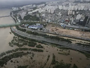 Sebagian jalan utama dan taman di dekat Sungai Han terendam banjir akibat hujan lebat di Seoul, Korea Selatan, Kamis (6/8/2020). Hujan lebat terus mengguyur Korea Selatan, mendorong pihak berwenang untuk menutup sebagian jalan raya dan mengeluarkan peringatan banjir. (AP Photo/Lee Jin-man)