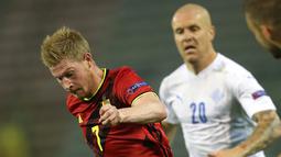 Gelandang timnas Belgia, Kevin De Bruyne menggiring bola dibayangi pemain timnas Islandia, Emil Hallfredsson pada matchday kedua UEFA Nations League A Grup 2 di King Baudouin Stadium, Rabu (9/9/2020) dini hari WIB. Timnas Belgia melibas Islandia dengan skor 5-1. (AP Photo/Francisco Seco)