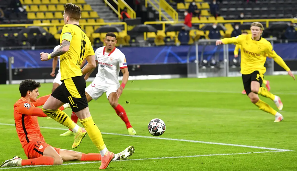 Pemain Borussia Dortmund Marco Reus mengoper bola ke Erling Haaland saat menghadapi Sevilla FC pada pertandingan leg kedua babak 16 besar Liga Champions di Dortmund, Jerman, Selasa (9/3/2021). Laga berakhir imbang 2-2. (Bernd Thissen/Pool via AP)