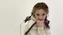 Nayeon tampak imut dengan rambut keriting yang kepang kanan-kiri menggunakan ikatan scrunchie. Instagram @twicetagram