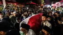 Saudara serta Kerabat mengangkat dan mendorong Peti Jenazah Ketua Dewan Pers Azyumardi Azra di rumah duka di Perumahan Puri Laras II, Cirendeu, Tangerang Selatan, Senin (19/9/2022) tengah malam. Azyumardi Azra meninggal dunia pada Minggu (18/9/2022) di rumah sakit Kedah, Selangor, Malaysia pukul 12.30 waktu setempat, dan rencana akan dimakamkan Selasa (20/9/2022) di Taman Makam Pahlawan (TMP) Kalibata. (Liputan6.com/Johan Tallo)