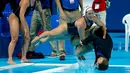 Anggota tim polo air putri AS mendorong pelatihnya, Adam Krikorian, ke kolam setelah meraih emas dengan mengalahkan Belanda di Kejuaraan Dunia Akuatik 2015 di Kazan, Rusia. (7/8/2015). (Reuters/Michael Dalder)