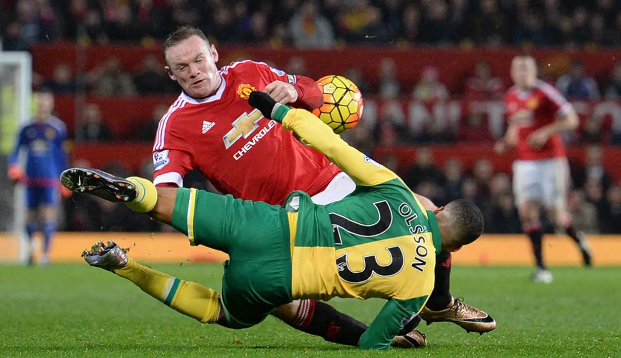 Striker MU, Wayne Rooney, berebut bola dengan pemain Norwich, Martin Olsson, pada laga Liga Premier Inggris di Stadion Old Trafford. (AFP/Oli Scarff)