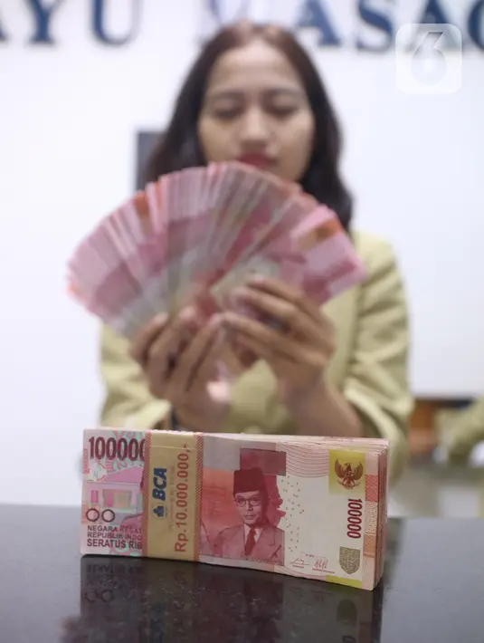 Pegawai menunjukkan mata uang rupiah di penukaran uang di Jakarta, Rabu (4/3/2020). Rupiah ditutup menguat 170 poin atau 1,19 persen menjadi Rp14.113 per dolar AS dibandingkan posisi hari sebelumnya Rp14.283 per dolar AS. (Liputan6.com/Angga Yuniar)