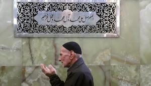 Muslim membaca sholawat di dekat kaligrafi bertuliskan sholawat (Wikimedia Commons)