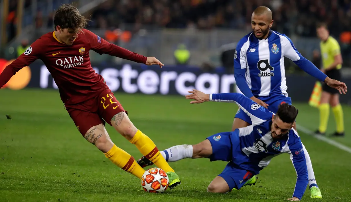 Gelandang AS Roma Nicolo Zaniolo (kiri) menggiring bola melewati bek FC Porto Alex Telles saat bertanding pada babak 16 besar Liga Champions di Stadion Olimpico, Roma, Italia, Selasa (12/2). Nicolo berhasil mencetak dua gol. (AP Photo/Andrew Medichini)
