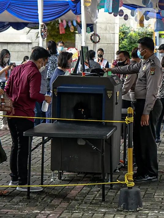 Polisi memeriksa barang bawaan jemaat saat misa Minggu Paskah di Gereja Katedral, Jakarta, Minggu (4/4/2021). Sejumlah personel gabungan TNI-Polri disipakan untuk melakukan pengamanan di sejumlah gereja pada perayaan Paskah. (Liputan6.com/Faizal Fanani)