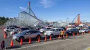 Orang-orang duduk di dalam mobil mereka di area observasi untuk memeriksa kemungkinan efek samping setelah mendapatkan suntikan vaksin di pusat vaksinasi Covid 19 skala besar yang didirikan di Six Flags Magic Mountain di Valencia, California, Selasa (2/2/2021). (VALERIE MACON/AFP)