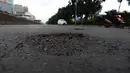 Kendaraan melintasi jalan berlubang di Jalan Gunung Sahari, Jakarta, Selasa (9/4). Meskipun sudah dilakukan penambalan, jalan raya tersebut sering rusak akibat beban kendaraan yang melintas di atasnya dan intensitas hujan yang belakangan ini cukup tinggi. (merdeka.com/Imam Buhori)