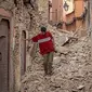 Seorang warga berjalan di antara reruntuhan bangunan setelah gempa berkekuatan 6,8 SR di Marrakesh, Maroko, Sabtu (9/9/2023). (Photo by FADEL SENNA / AFP)