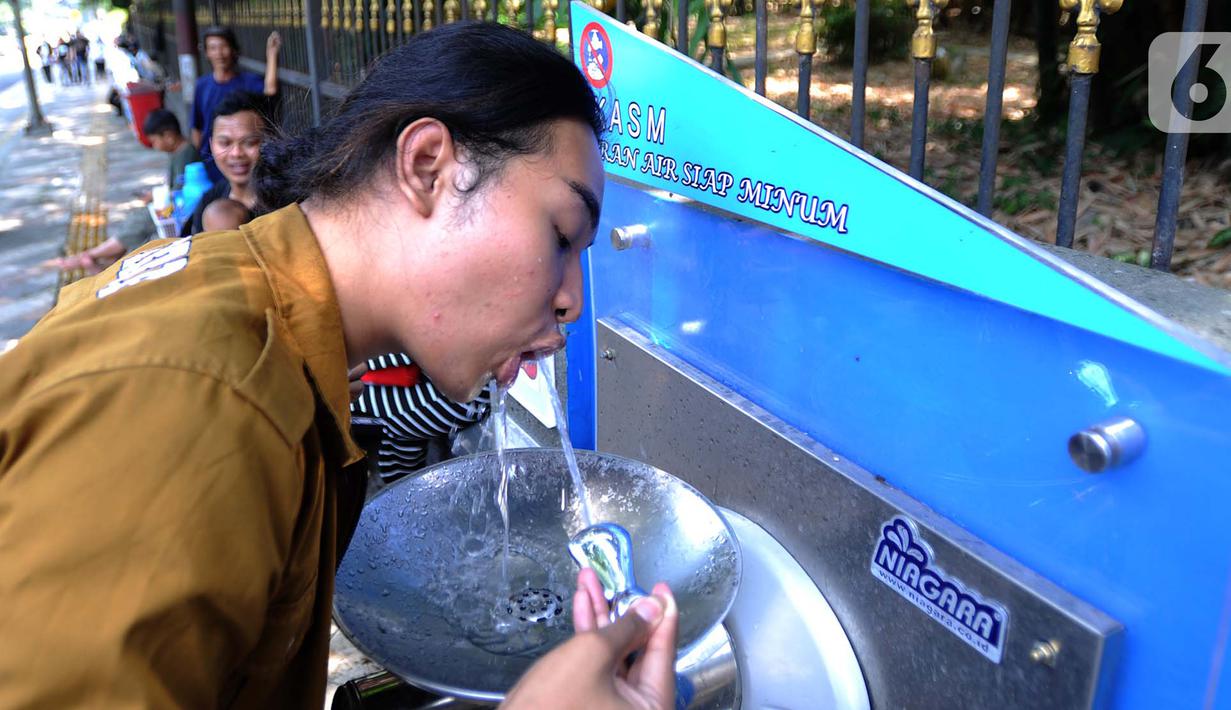 Warga minum dari Keran Air Siap Minum (KASM) yang terpasang di dekat Pintu 2 Kebun Raya Bogor, Jawa Barat, Minggu (6/10/2019). Pemkot Bogor melalui PDAM Tirta Pakuan membuat KASM di pendestrian Jalan Ir H Djuanda untuk menekan angka konsumsi botol dan gelas plastik. (merdeka.com/Arie Basuki)