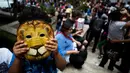 Seorang anak mengenakan topeng Cowardly Lion dari “The Wizard of Oz” lengkap dengan filter khusus dibagian lubang matanya saat menikmati gerhana matahari di Mexico City, Senin (21/8). (Rebecca Blackwell/AP)