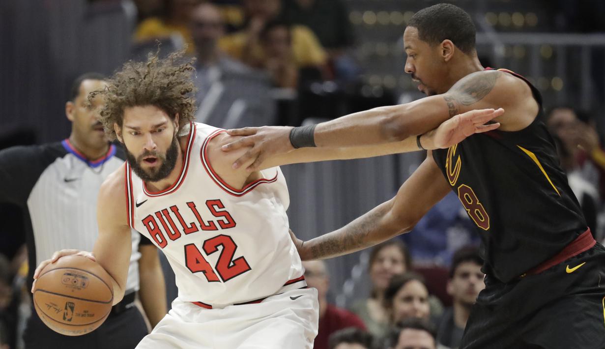 Pemain Chicago Bulls, Robin Lopez (kiri) menggiring bola melewati adangan pemain Cleveland Cavaliers, Channing Frye (8) pada laga NBA basketball game di Quicken Loans Arena, Cleveland, (21/12/2017). Cleveland menang 115-112.  (AP/Tony Dejak)