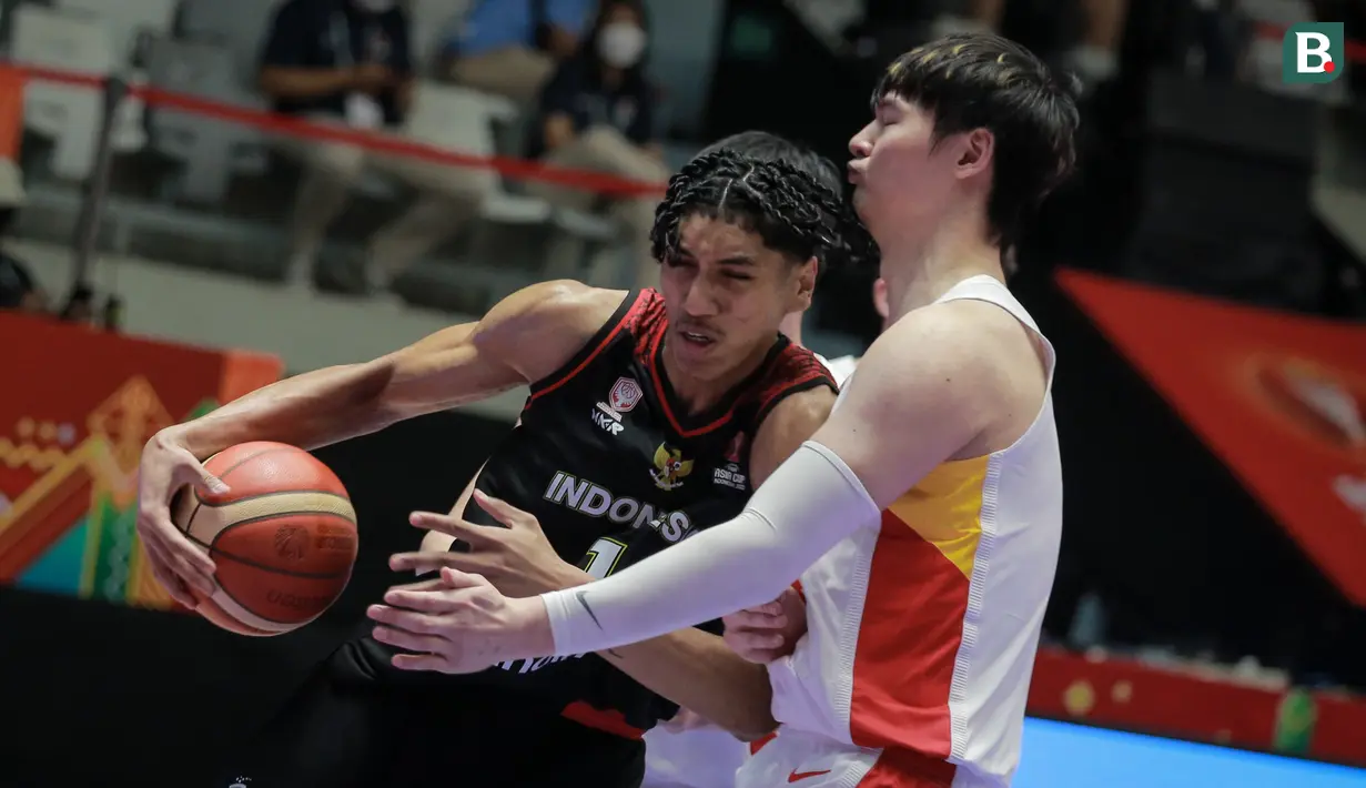 Pemain Timnas Basket Indonesia, Derrick Michael Xzavierro (kiri) berusaha melewati pemain Timnas Basket China, Wang Zhelin saat laga playoff perempat final FIBA Asia Cup 2022 antara Timnas Basket China melawan Timnas Basket Indonesia di Istora Senayan, Jakarta, Senin (18/07/2022). (Bola.com/Bagaskara Lazuardi)