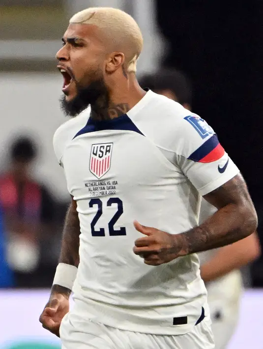 <p>Pemain Amerika Serikat DeAndre Yedlin melakukan selebrasi setelah rekan setimnya Haji Wright mencetak gol ke gawang Belanda pada pertandingan sepak bola babak 16 besar Piala Dunia 2022 di Stadion Internasional Khalifa, Doha, Qatar, 3 Desember 2022. DeAndre Yedlin memadukan potongan teknik skin dengan pola zigzag sehingga membuat rambutnya membentuk motif seperti gunung. (Alberto PIZZOLI/AFP)</p>