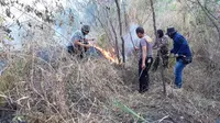 Gabungan anggota TNI dan Polisi dari Polsek Tarogong Kaler, bersigap memadamkan titik api dalam kebakaran hutan di kaki Hutan Gunung Guntur Beberapa waktu lalu (Liputan6.com/Jayadi Supriadin)