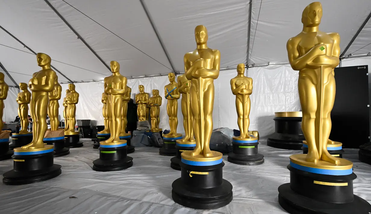 Patung Oscar menunggu lukisan Oscar 2023 di sepanjang Hollywood Boulevard selama persiapan Academy Awards ke-95 di Los Angeles, California, Rabu (8/3/2023). Komedian pemenang penghargaan Emmy di Amerika, Jimmy Kimmel kembali terpilih untuk membawakan acara Oscar tahun ini. (Photo by Patrick T. Fallon / AFP)