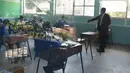 Kepala sekolah SD Kongoni, George Njau (kanan), mendampingi murid-muridnya di dalam ruang kelas di Nairobi, Kenya, Senin (12/10/2020). Kenya membuka kembali sebagian sekolah pada Senin 10 Oktober, setelah ditutup sejak Maret lalu akibat pandemi corona COVID-19. (Simon MAINA/AFP)