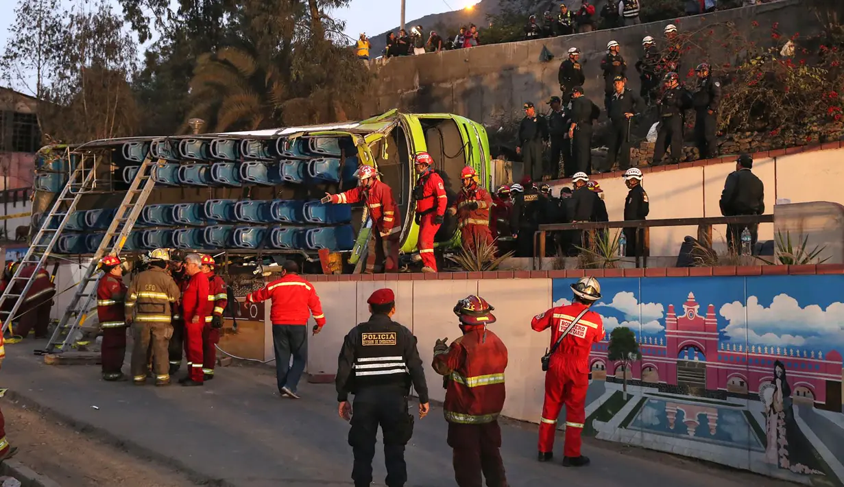 Petugas pemadam kebakaran saat mengevakuasi bus usai kecelakaan di Lima, Peru, (9/10). Menurut petugas pemadam kebakaran, sedikitnya tujuh orang tewas setelah  bus wisata tersebut keluar jalur saat turun bukit di distrik Rimac. (AFP Photo/Andina/Ho)