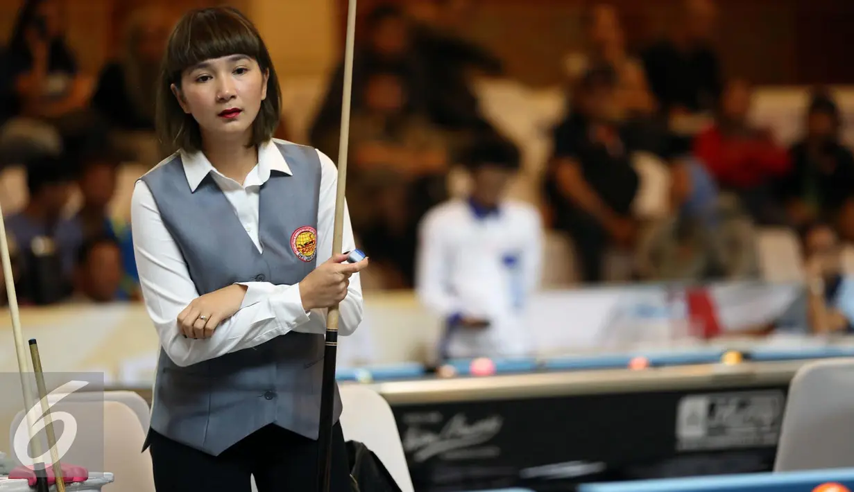 Pebiliar putri DKI Jakarta, Angeline M Ticoalu melihat posisi bola saat laga penyisihan 10 ball PON XIX Jabar di Graha Manggala Siliwangi, Bandung, Kamis (22/9). Angeline berhasil mengalahkan pebiliar Papua, Ari S Wati. (Liputan6.com/Helmi Fithriansyah)