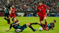 Penyerang Muenchen, Thomas Muller berusaha melewati dua pemain Arsenal pada lanjutan Grup F liga champions di stadion Allianz Arena, Munich, Jerman (4/11). Muenchen menang atas Arsenal dengan skor 5-1. (Reuters/John Sibley) 