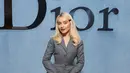 Sabrina Carpenter tampil manis dengan busana tertutup yang clean. Memadukan setelan blazer dan rok ruffle dengan heels gold dan tas Lady Dior [Dior]