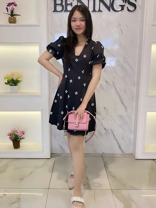 Kirana juga nampak elegan dengan mini dress hitam bermotif dipadukan sandal slop pink yang serasi dengan mini bagnya. @kiranavelovoiceee