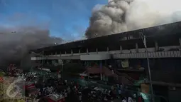 Asap hitam nan pekat membumbung tinggi di lokasi kebakaran yang melanda Pasar Senen, Jakarta Pusat, Kamis (19/1). Ada 42 unit mobil pemadam kebakaran yang dikerahkan ke lokasi kebakaran. (Liputan6.com/Faizal Fanani)