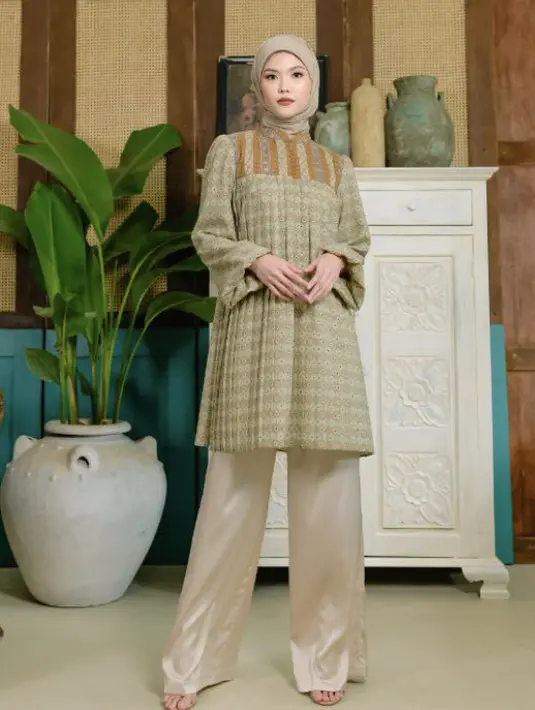 <p>Tunik cokelat dengan motif seperti dari Muda Padma ini bisa dipadukan dengan pallzo pants atau skirt plisket. Warna kerudung sesuaikan dengan atasan. Credit: Blibli.</p>