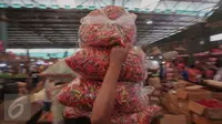 Pedagang memanggul plastik cabai di Pasar Induk Kramat Jati, Jakarta, Selasa (24/11). Harga cabai merah keriting kini dipatok Rp 25 ribu per kg, sementara cabai merah rawit dipatok Rp 28 ribu per kg. (Liputan6.com/Angga Yuniar)