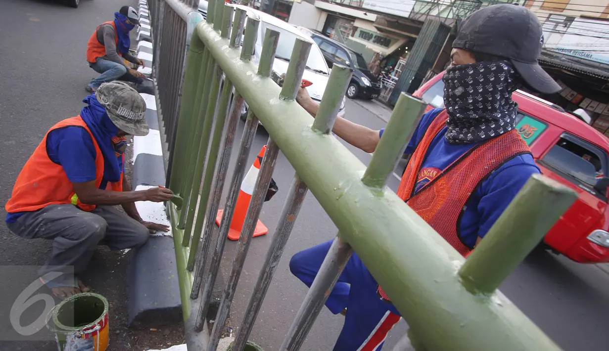 Sejumlah pekerja melakukan pengecatan pembatas jalan di kawasan Pasar Minggu, Jakarta Selatan, Rabu (26/10). Pengecatan dilakukan sebagai bentuk perawatan agar pagar pembatas tetap rapi dan tidak tampak kusam. (Liputan6.com/Immanuel Antonius)