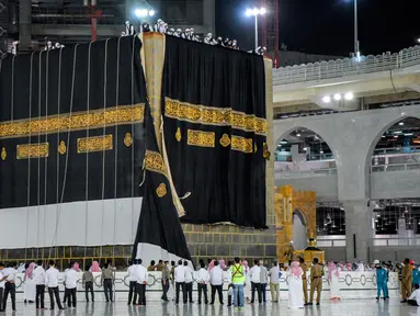 Kiswah baru, atau kain hitam dipasangkan di situs paling suci Islam, Ka'bah di Mekah (29/7/2020). Kiswah adalah kain hitam dengan bordir emas yang menutupi Ka'bah di Makkah, Saudi Arabia diganti setiap tahun selama ibadah haji menjelang perayaan Idul Adha. (Saudi Media Ministry via AP)