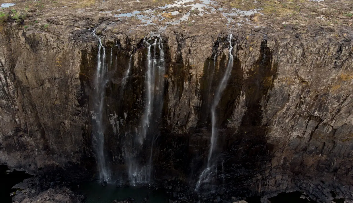 Pemandangan air terjun Victoria, salah satu air terjun terbesar di dunia, yang terletak di perbatasan Zimbabwe dan Zambia pada 10 Desember 2019. Menurut pejabat setempat, pada tahun ini Air Terjun Victoria mengalami penurunan debit air yang belum pernah terjadi sebelumnya. (ZINYANGE AUNTONY/AFP)