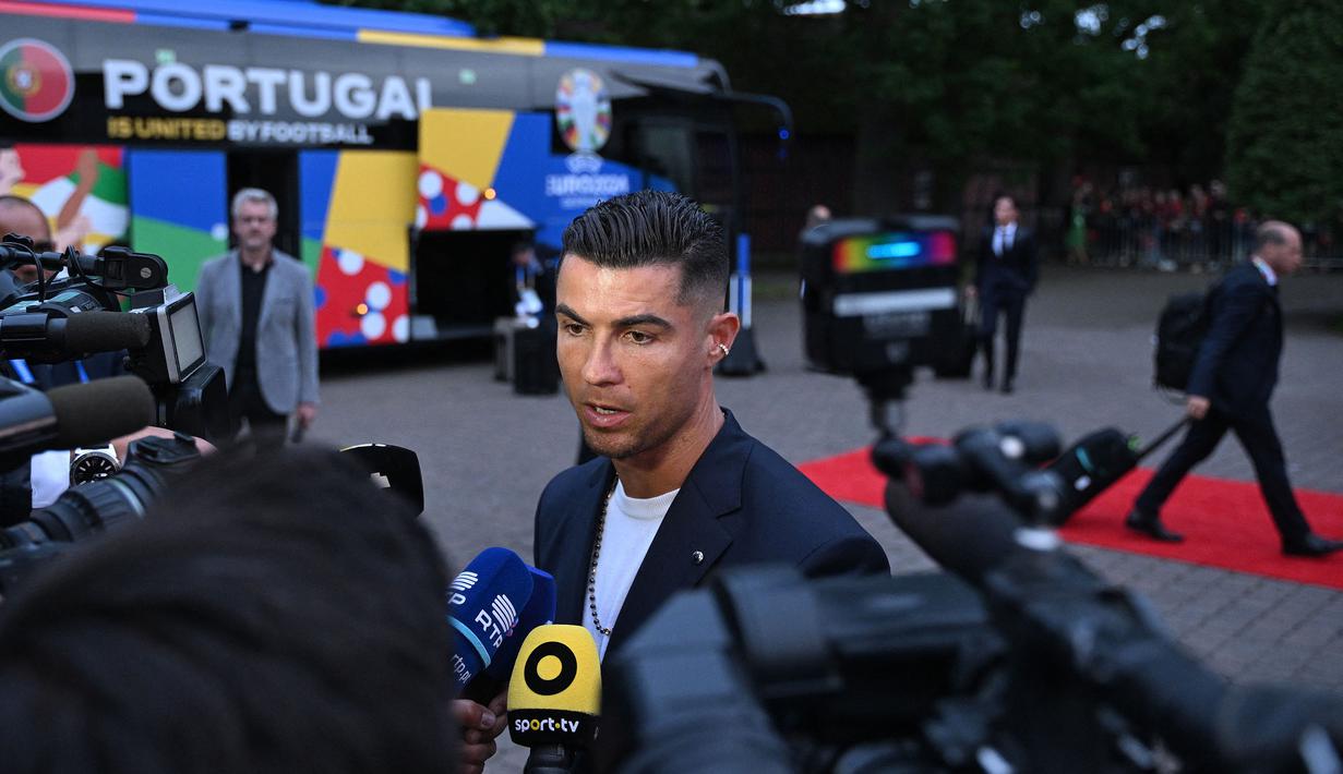 Pemain Timnas Portugal, Cristiano Ronaldo memberikan keterangan kepada awak media saat tiba di hotel tempat menginap jelang Euro 2024 di Harsewinkel, Jerman, Rabu (13/06/2024) waktu setempat. (AFP/Patricia De Melo Moreira)