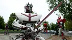 Sebuah robot memegang sebuah pedang dipamerkan di kota Zagreb, Kroasia (18/4). Robot yang terbuat dari mobil bekas ini terlihat mirip karakter film Transformers yang merupakan karya seniman muda asal Montenegro, Danilo Baletic. (REUTERS/Antonio Bronic)