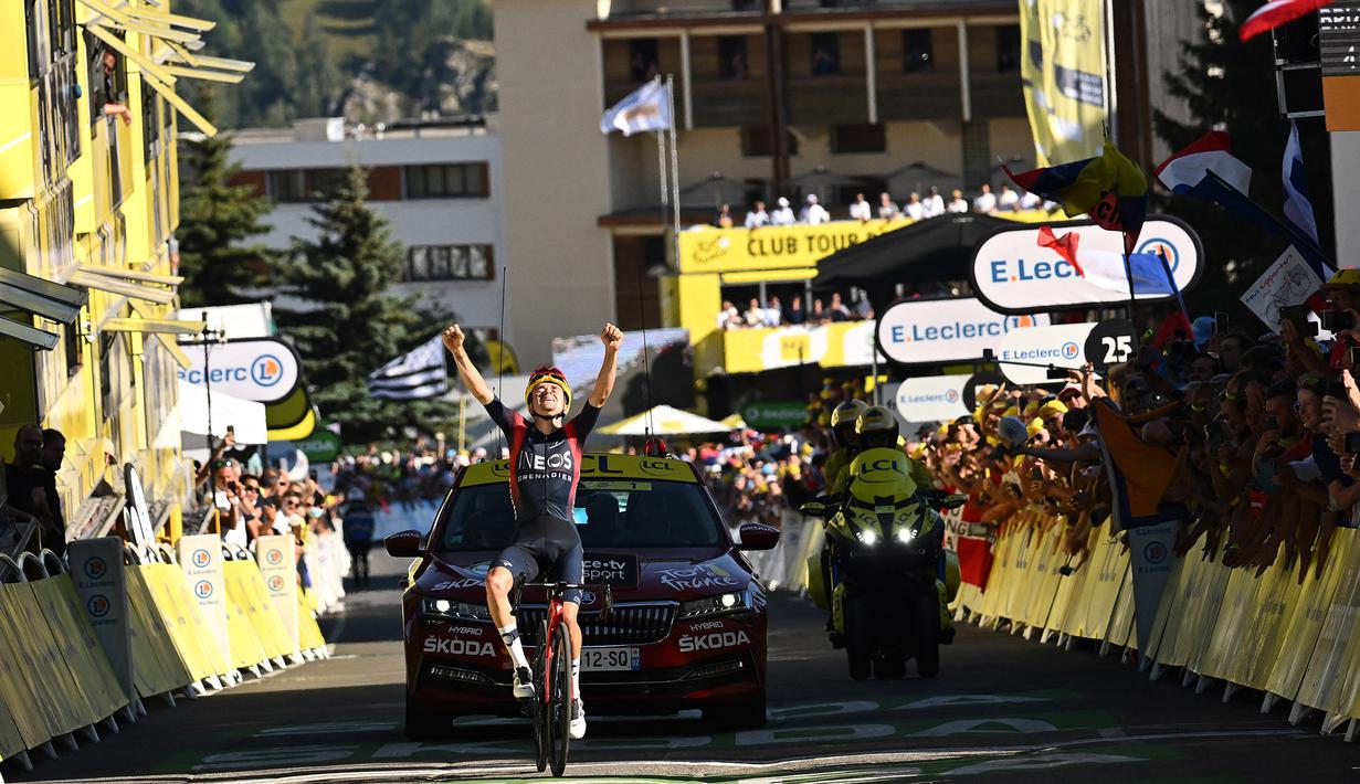 Pebalap tim Ineos Grenadiers, Thomas Pidcock melakukan selebrasi saat melintasi garis finis pada Stage 12 Tour de France 2022 yang menempuh rute sepanjang 165,1 km dari Briancon hingga L'Alpe-d'Huez, di Pegunungan Alpen, Prancis, Jumat (14/07/2022). (AFP/Marco Bertorello)