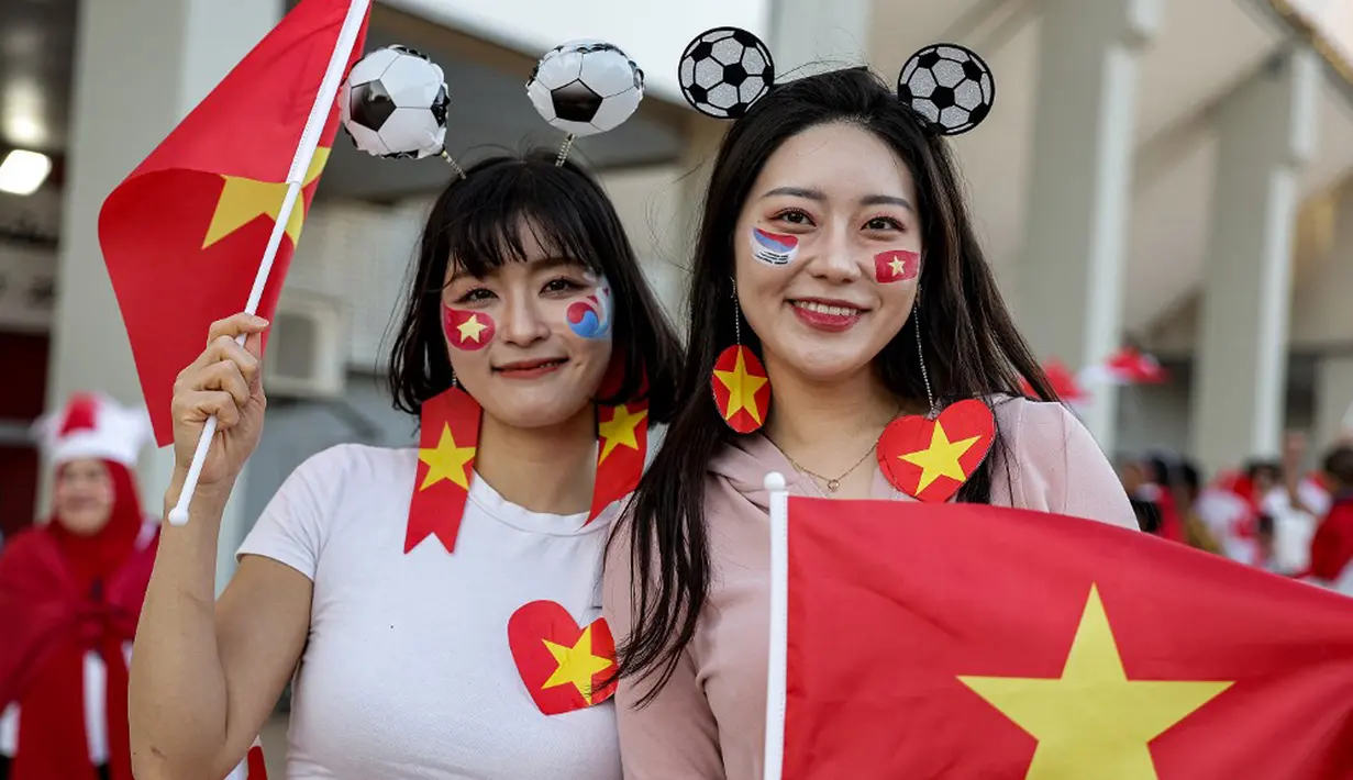 Suporter Vietnam berpose sebelum dimulainya pertandingan sepak bola Grup D Piala Asia 2023 antara Vietnam dan Indonesia di Stadion Abdullah bin Khalifa, Doha, Qatar, Jumat (19/1/2024). (KARIM JAAFAR/AFP)